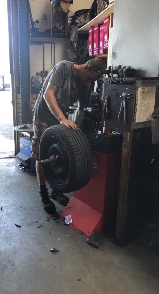 Een monteur rolt een band naar de balanceermachine